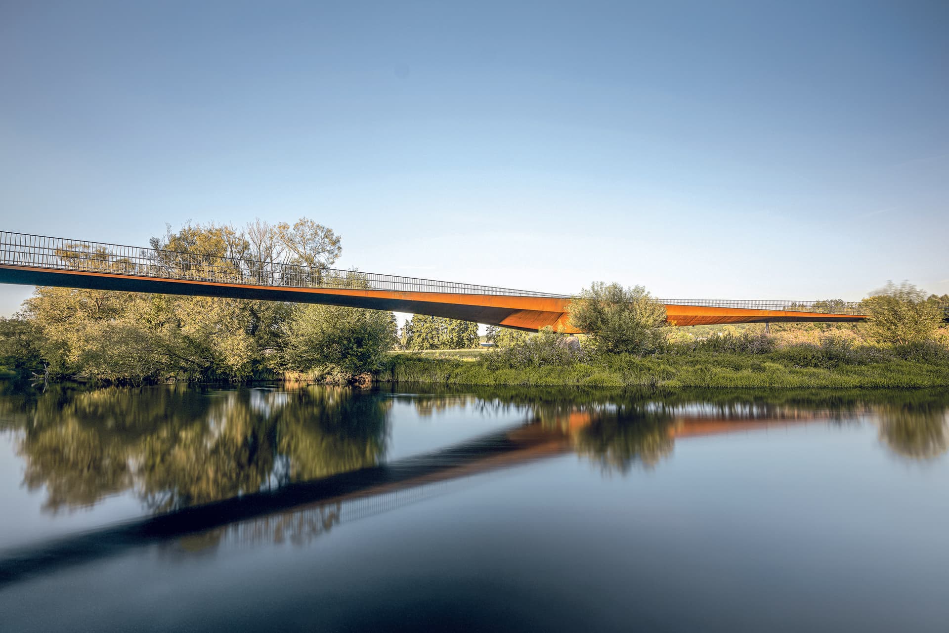 Die schlanke Silhouette der Regenbrücke Roding integriert sich zurückhaltend in die Landschaft und öffnet neue Wege zwischen Stadt und Natur. (© FOTOGRAFIEIMRAUM)