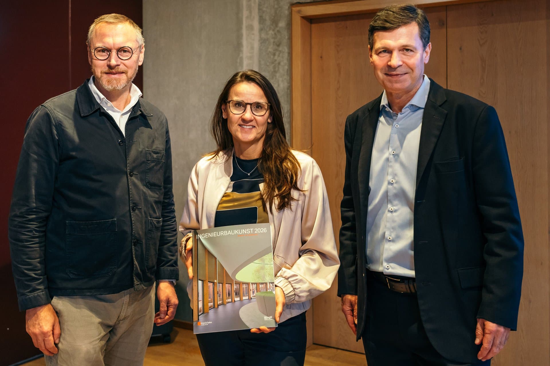 Dr. Stefan Weihrauch, Präsident der Hamburgischen Ingenieurkammer-Bau und Dr. Bernhard Hauke, Verlag Ernst & Sohn, übergeben der Hamburger Senatorin für Stadtentwicklung und Wohnen Karen Pein die Ingenieurbaukunst 2026. Foto Stefan Hähnel